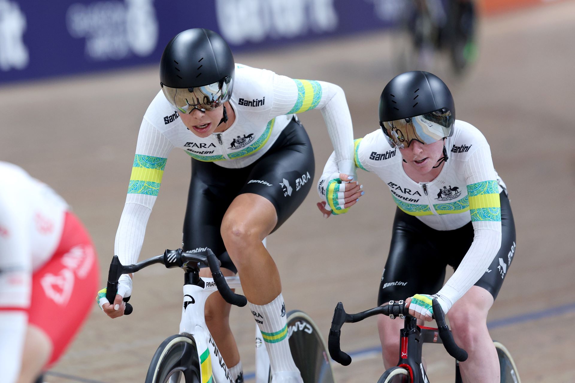 Georgia Baker and Alexandra Manly, cyclists for the ARA Australian Cycling Team, perform a handsling during the Madison at the 2023 UCI Track Cycling World Championships in Glasgow